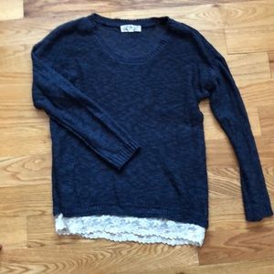 Lightweight sweater with lace trim at bottom.